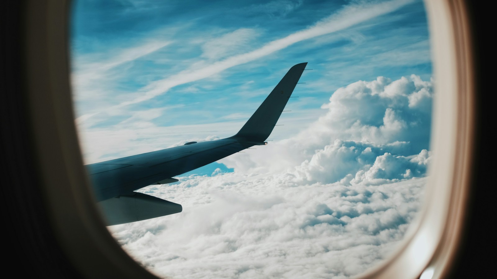 Pessoa fotografando a asa do avião pela janela durante o voo