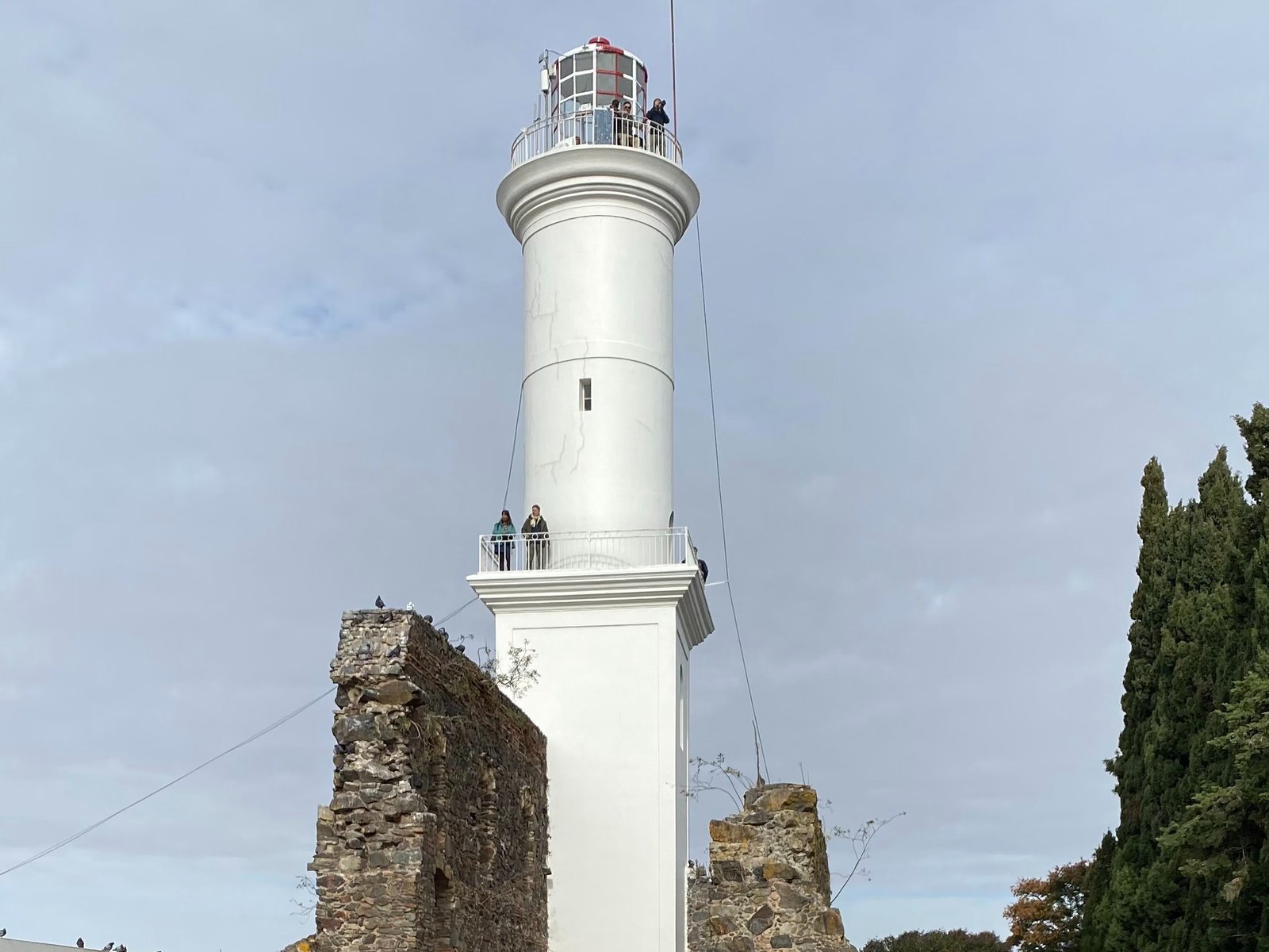 O farol branco de Colônia do Sacramento erguido entre as ruínas de pedra do Convento de São Francisco