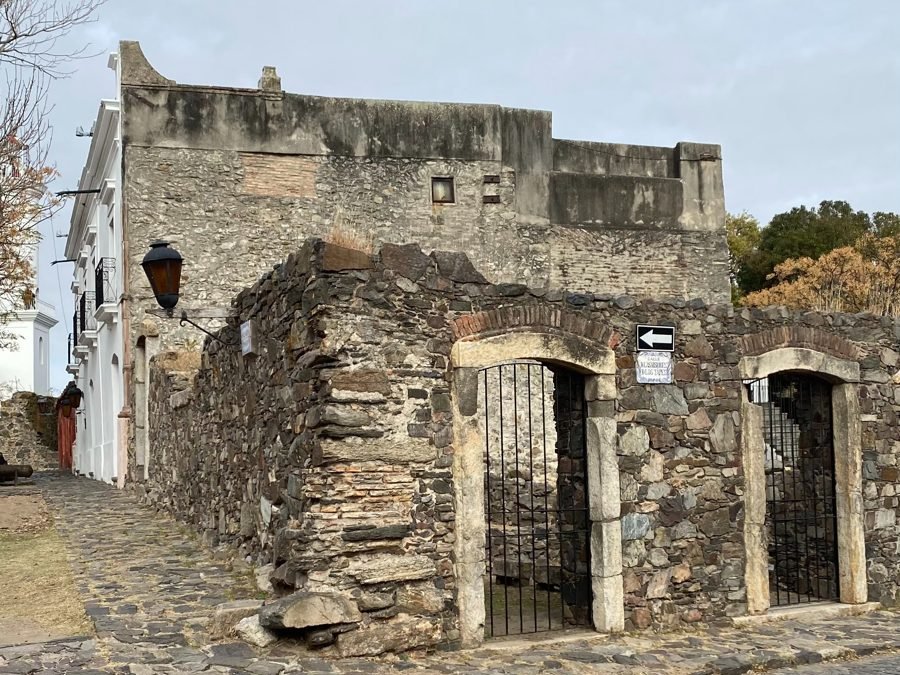 Muro de pedra e portões de ferro em ruínas no Bairro Histórico de Colônia do Sacramento