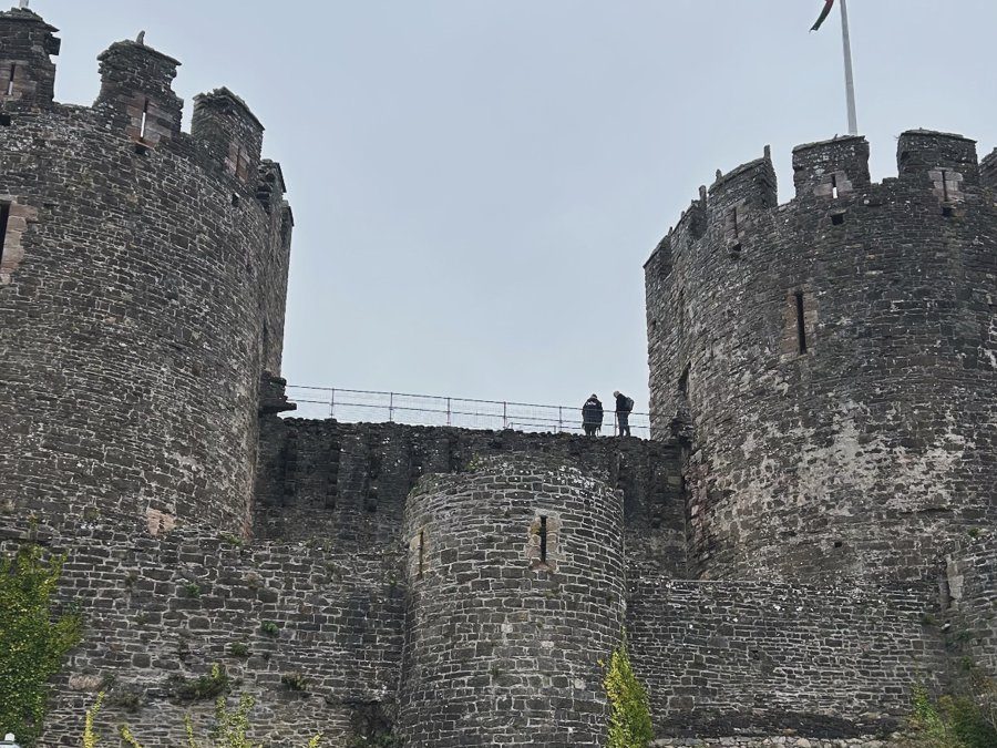 Torres do Castelo de Conwy com a bandeira galesa do dragão vermelho no alto