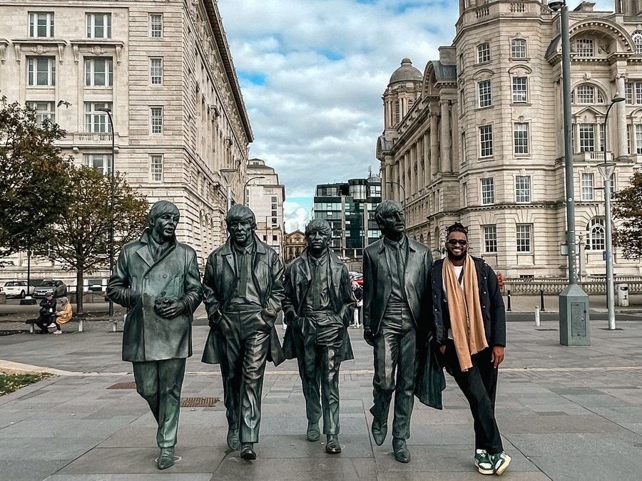José Pedro ao lado da estátua dos Beatles no Pier Head, em Liverpool