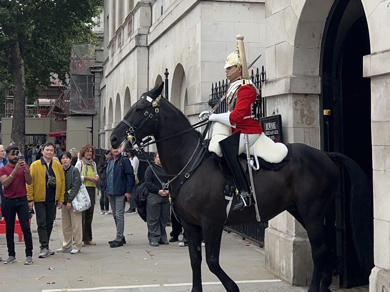 Guarda real a cavalo, de túnica vermelha e capacete dourado, na Horse Guards, em Londres