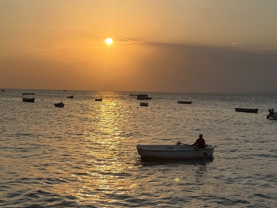 Pôr do sol sobre a Baía de Todos-os-Santos, com um pescador num barco a remo