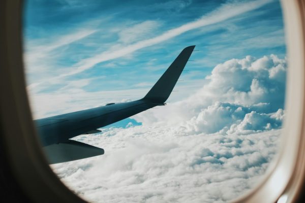 Pessoa fotografando a asa do avião pela janela durante o voo
